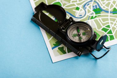 retro and black compass on map on blue  clipart