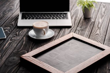 selective focus of chalk board near cup of coffee and laptop on table, e-commerce concept clipart