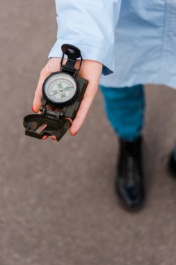cropped view of woman holding retro compass in hand outside  clipart