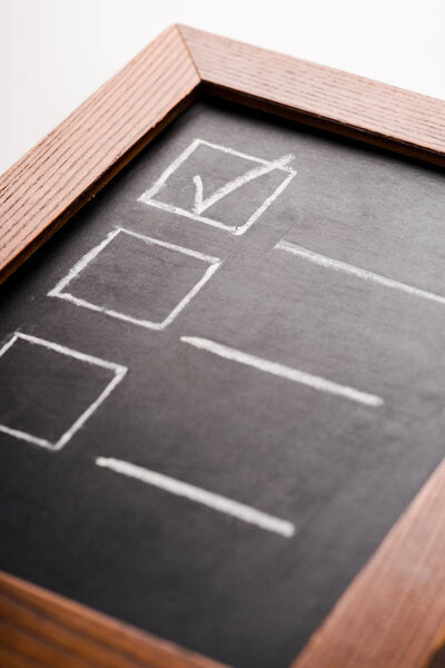 close up of chalk board with check mark isolated on white 