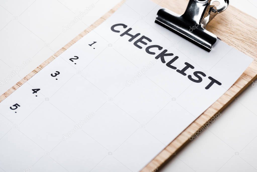 wooden clipboard with checklist lettering on paper isolated on white 