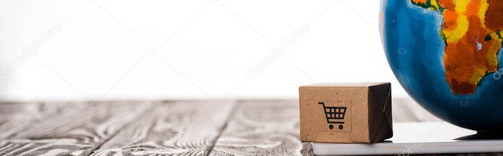 panoramic shot of toy box and globe on digital tablet isolated on white, e-commerce concept