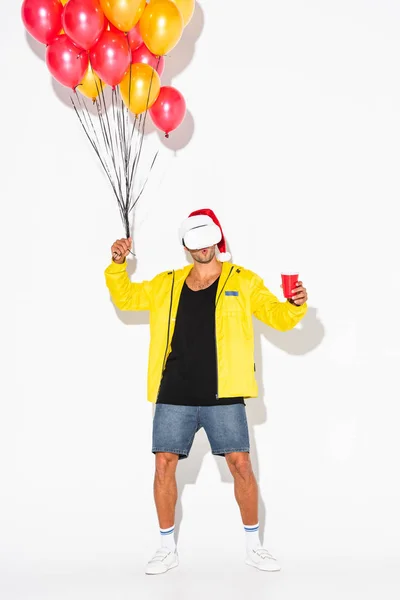 Förvånad Man Virtuell Verklighet Headset Håller Plast Kopp Och Ballonger — Stockfoto