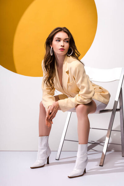 beautiful girl sitting on chair on white and orange 