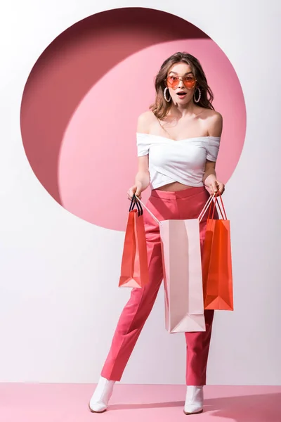 Chica Sorprendida Gafas Sol Sosteniendo Bolsas Compras Blanco Rosa — Foto de Stock