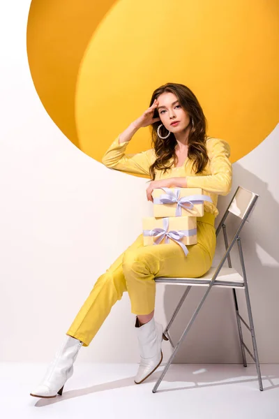 Mulher Atraente Sentado Cadeira Segurando Presentes Laranja Branco — Fotografia de Stock