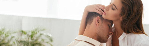 панорамный снимок подруги с закрытыми глазами, обнимающейся с парнем в квартире
 