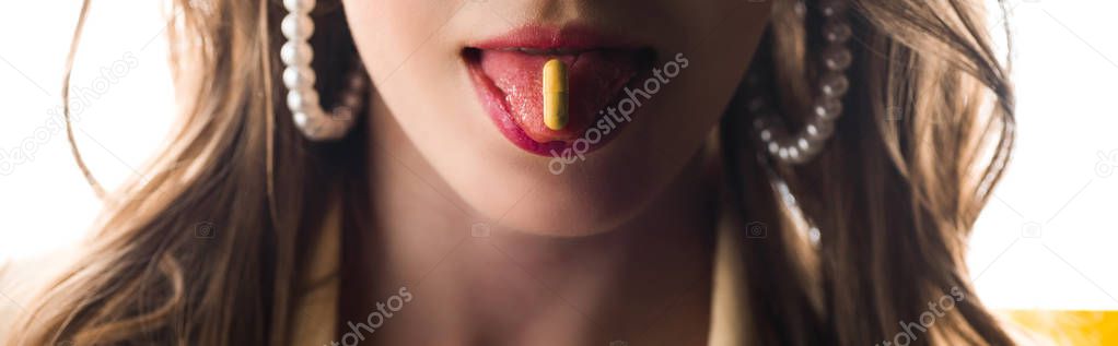 panoramic shot of woman sticking out tongue with yellow pill on white 