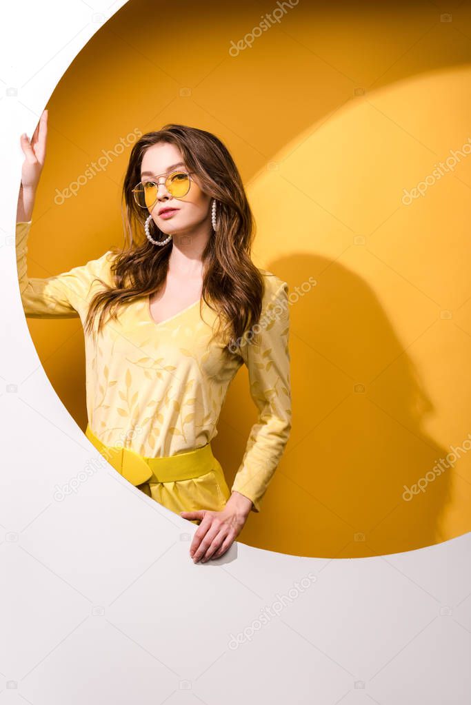 beautiful woman in sunglasses standing on orange and white 