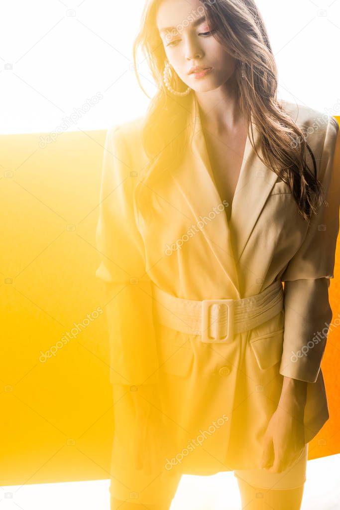 young trendy woman in blazer with belt on orange and white 