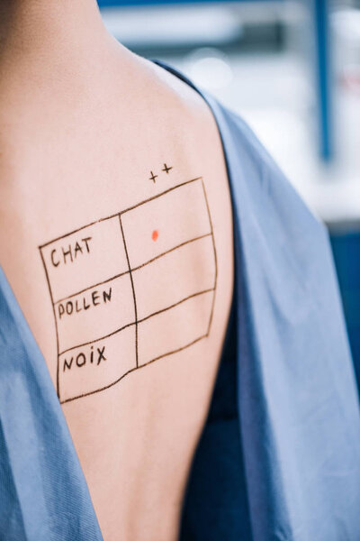 обрезанный вид женщины с надписью на спине
 