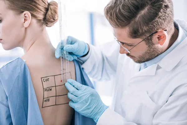 Alergista Barbudo Sosteniendo Regla Cerca Del Paciente Con Espalda Marcada — Foto de Stock