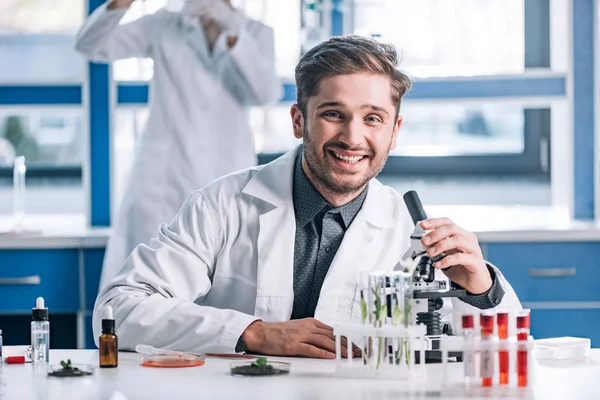 Selektivt Fokus Glad Biokemist Nära Mikroskop Och Anläggningar Provrör — Stockfoto