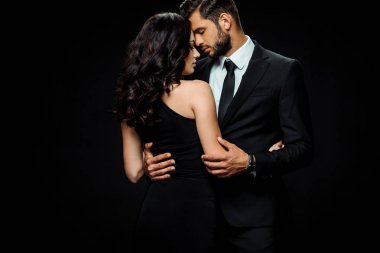 attractive woman in dress hugging bearded man isolated on black  clipart