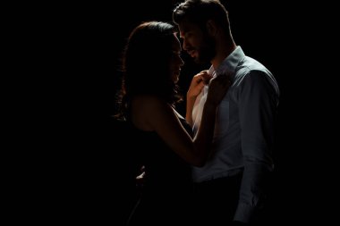 Siyah bir kadınla duran sakallı adamın yan görüntüsü. 