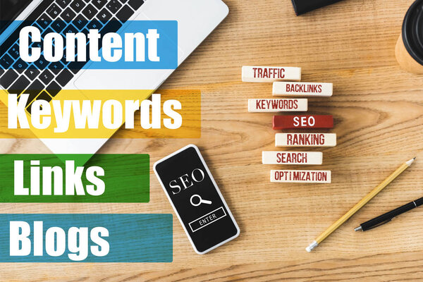 вид сверху деревянных прямоугольников с иллюстрацией концептуальных слов seo, смартфона, ноутбука, ручки и карандаша
 