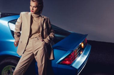 Eski model arabanın yanında duran çekici ve şık bir kadının yüksek açılı görüntüsü
