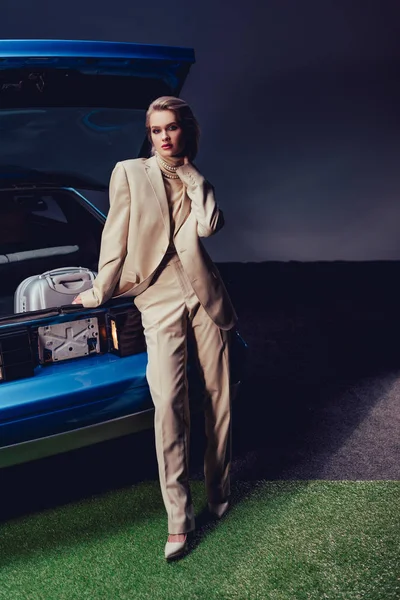 穿着西服的漂亮而时髦的女人站在复古汽车旁边 — 图库照片