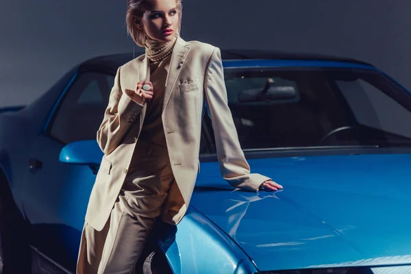 レトロな車の近くに立つスーツ姿の魅力的でスタイリッシュな女性 — ストック写真