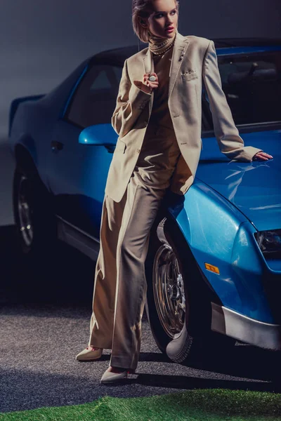レトロな車の近くに立つスーツ姿の魅力的でスタイリッシュな女性 — ストック写真
