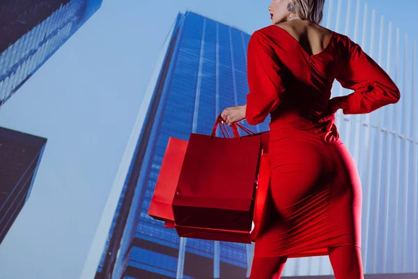 Vista Cortada Mulher Elegante Vestido Vermelho Segurando Sacos Compras Fundo — Fotografia de Stock