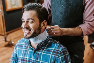 barber fixing collar around neck of happy man  clipart