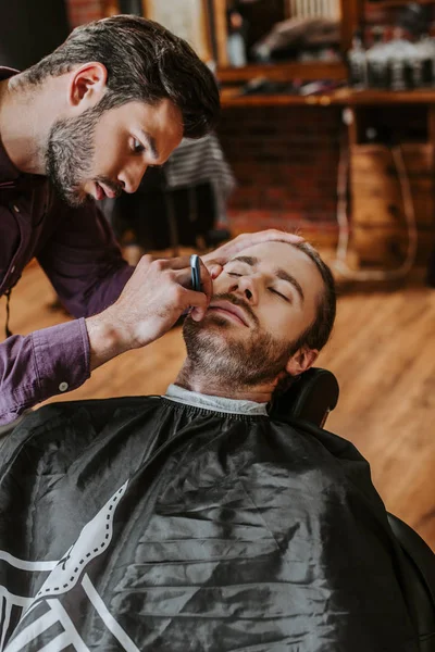 Handsome Barber Holding Razor While Shaving Man — Stock Photo, Image