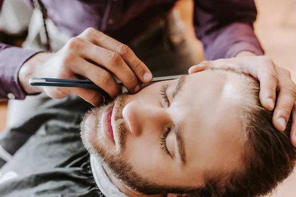Selective Focus Barber Holding Razor While Shaving Handsome Man — Stock Photo, Image