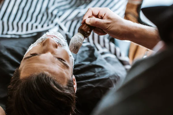 Draufsicht Des Friseurs Anwendung Rasierschaum Auf Das Gesicht Des Mannes — Stockfoto