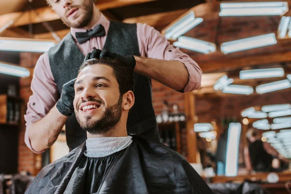 Holič Černé Latexové Rukavice Dotýkající Vlasů Šťastného Muže Holičství — Stock fotografie