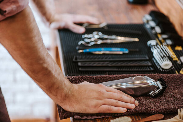 cropped view of barber standing near hairdressing equipment 