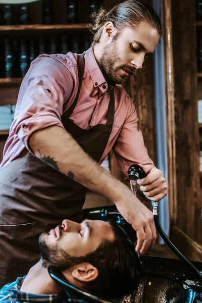 Stilig Frisör Med Tatuering Tvätta Hår Skäggig Man Med Slutna — Stockfoto