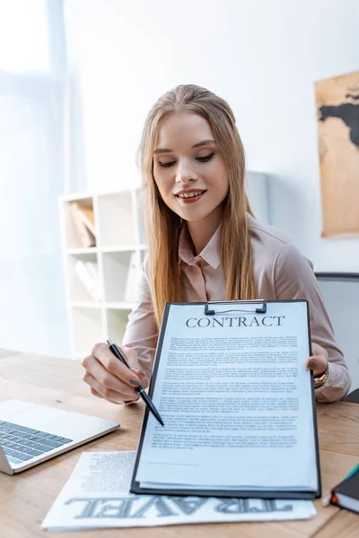 Lächelndes Reisebüro Zeigt Mit Stift Auf Vertrag Auf Klemmbrett — Stockfoto