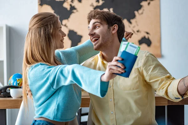 Happy Girl Hugging Cheerful Boyfriend While Holding Passports Air Tickets — Stock Photo, Image