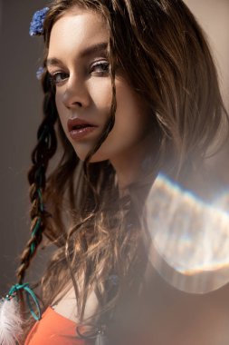 boho girl with braids in hairstyle posing on grey with lens flares  clipart