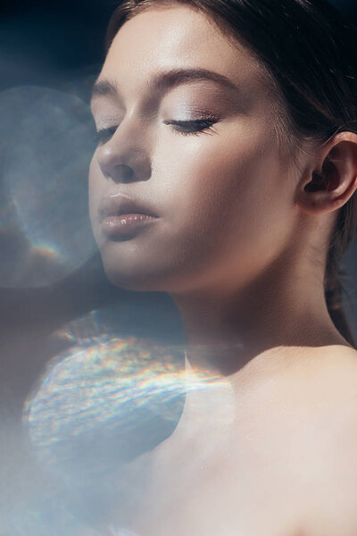 portrait of tender nude girl on grey with lens flares