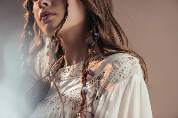Saç stili örgülü bohem bir kadının gri renkli flaşlı beyaz boho elbisesiyle poz vermesi. 