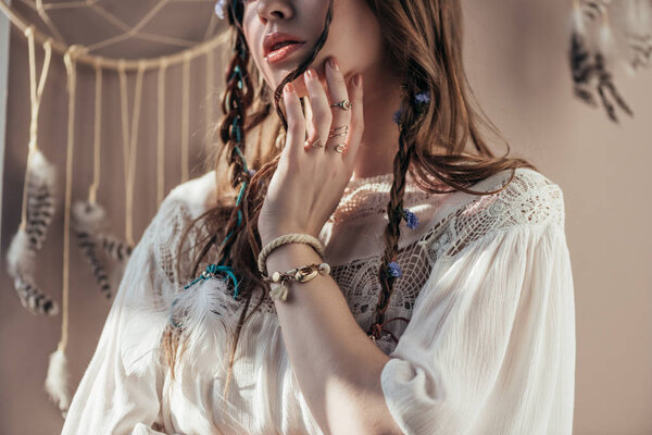 cropped view of girl with braids in white boho dress on beige with dream catcher