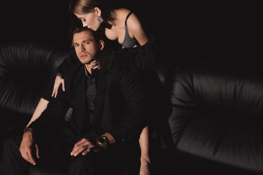 Çekici bir kadının yakışıklı bir adamı kucaklaması ve öpmesi, siyahların arasında izole edilmiş.