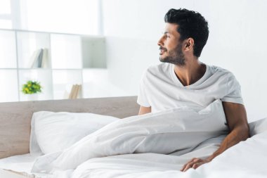 handsome and smiling bi-racial man looking away in morning 