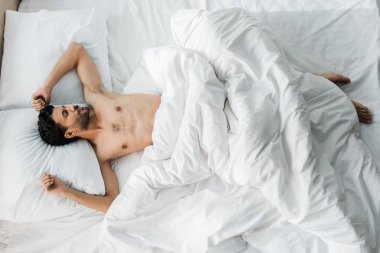 Sabahları yatakta uyuyan seksi ve yakışıklı, çift ırklı bir adam. 