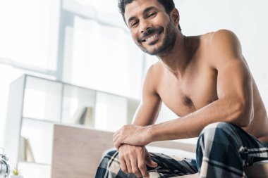Sabahları kameraya gülümseyen yakışıklı ve seksi iki ırklı adamın düşük açılı görüntüsü. 
