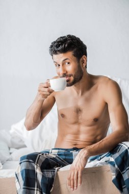 Yakışıklı ve gülümseyen çift ırklı bir adam. Sabahları kahve içiyor. 