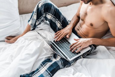 Sabahları dizüstü bilgisayar kullanan iki ırklı seksi bir adam görüntüsü. 