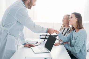 pozitif doktor tatlı çocuğun annesiyle tokalaşıyor.
