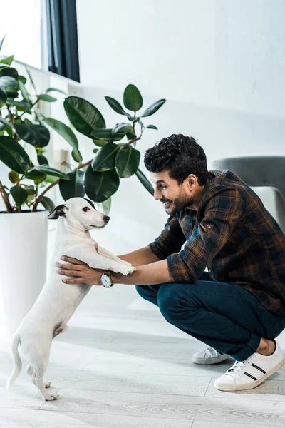 Vista Lateral Hombre Racial Guapo Sonriente Sosteniendo Jack Russell Terrier — Foto de Stock