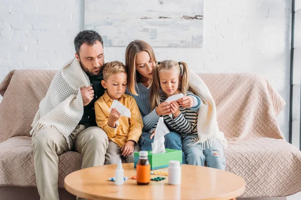 Família Doente Envolto Cobertor Sentado Sofá Perto Mesa Com Medicamentos — Fotografia de Stock