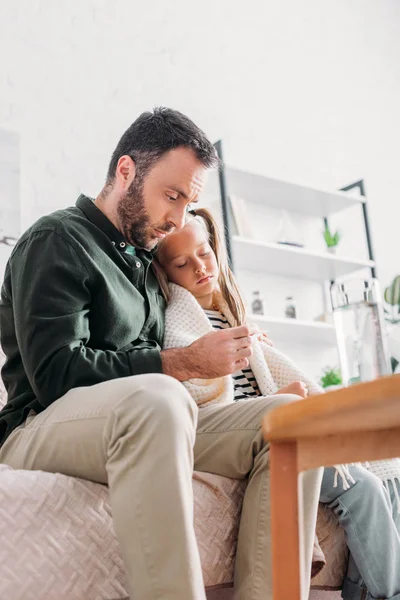 Upset Man Looking Thermometer While Hugging Sick Daughter — Stock Photo, Image