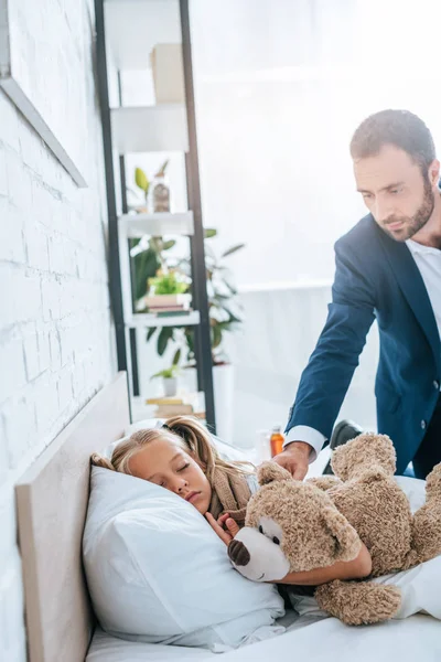 Attentive Father Putting Teddy Bear Sick Sleeping Daughter — Stock Photo, Image