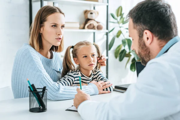 Seriöser Kinderarzt Schreibt Rezept Der Nähe Aufmerksamer Mutter Und Tochter — Stockfoto